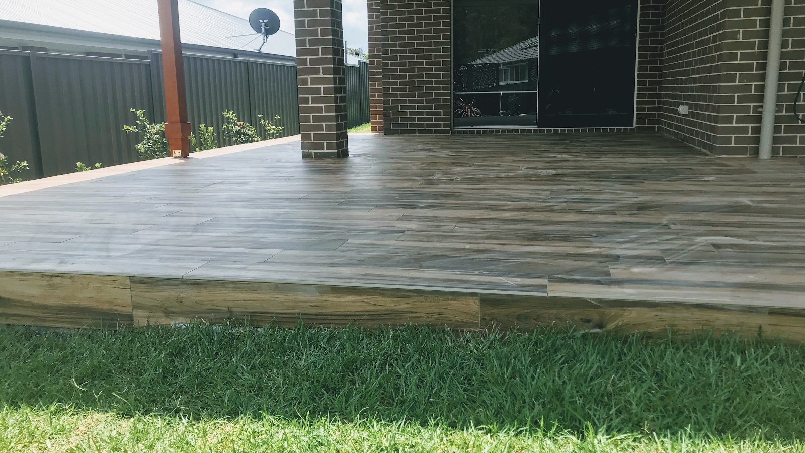 A timber-look tiled deck at dusk, laid by Clear Cut Tiling in the Shoalhaven