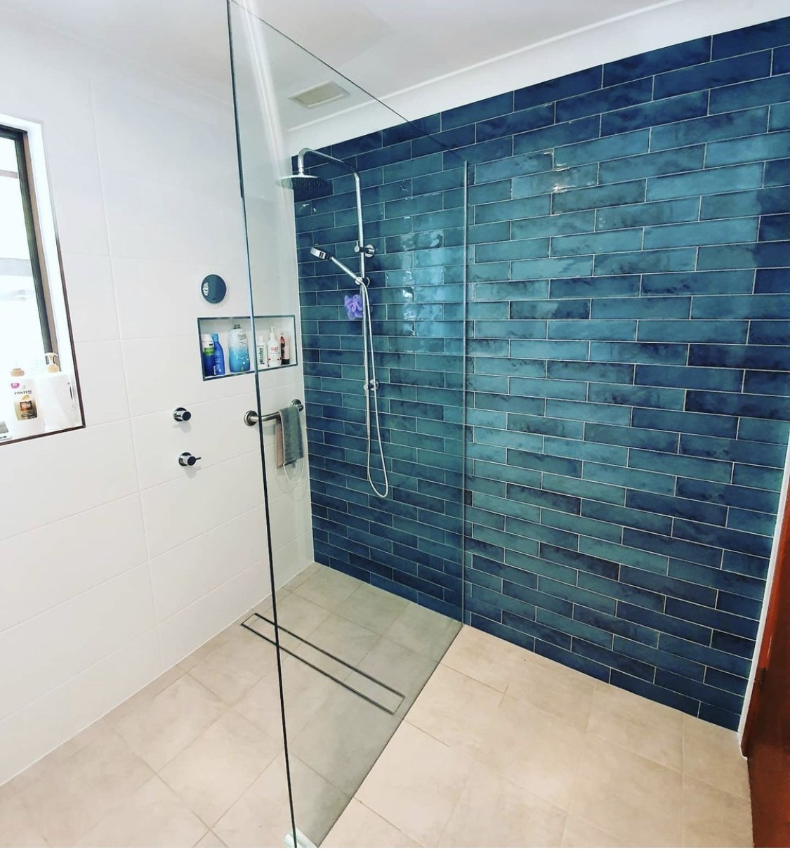 A striking blue mosaic feature shower wall tiled by Clear Cut Tiling