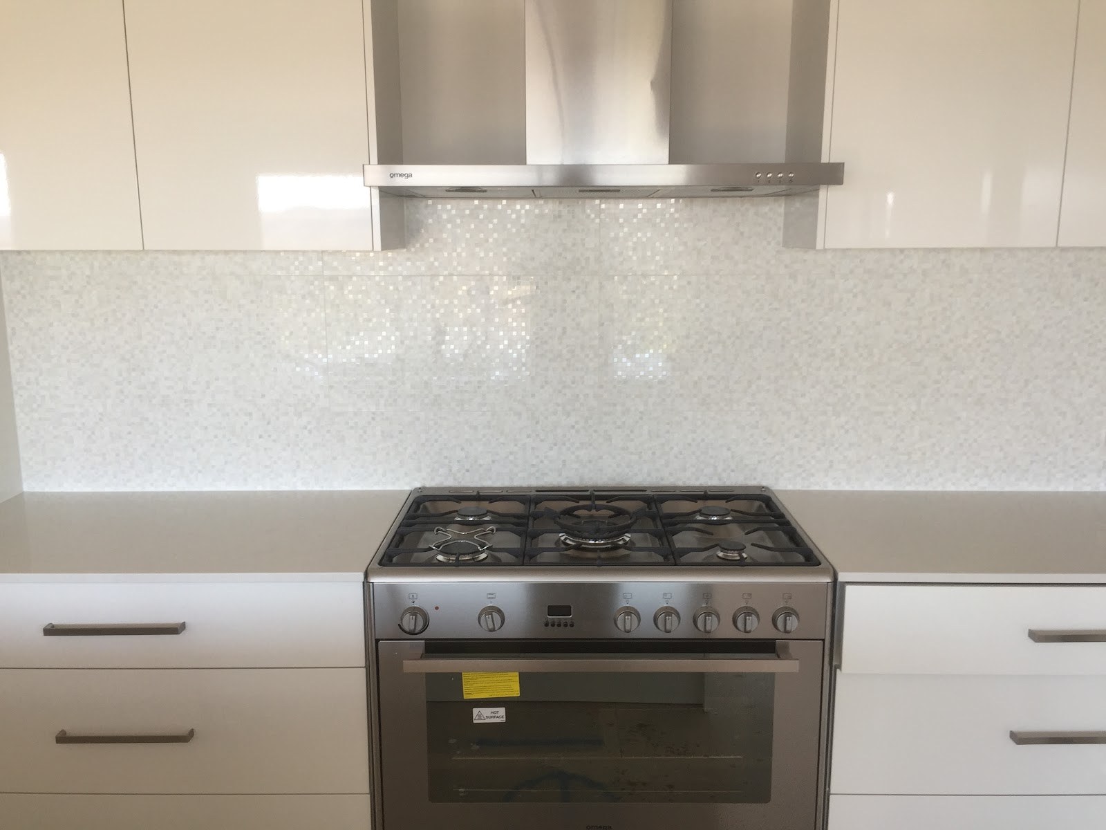 A finished kitchen splashback tiled behind a freestanding oven
