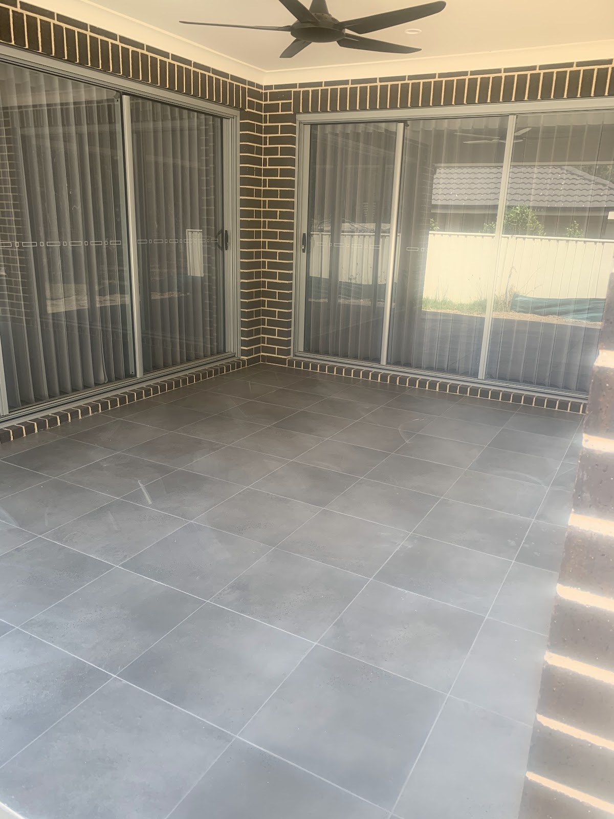 An alfresco area with large-format floor tiles laid by Clear Cut Tiling