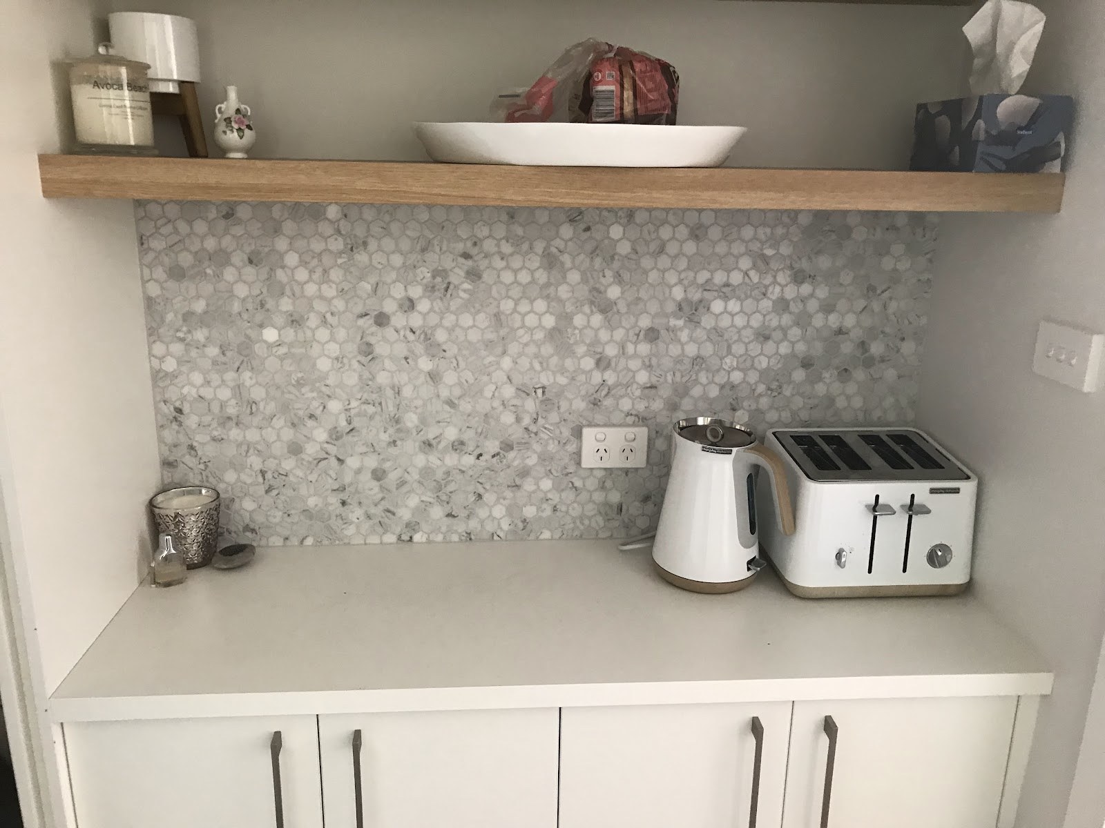A kitchen splashback in penny mosaic tiles under a timber shelf, tiled by Clear Cut Tiling