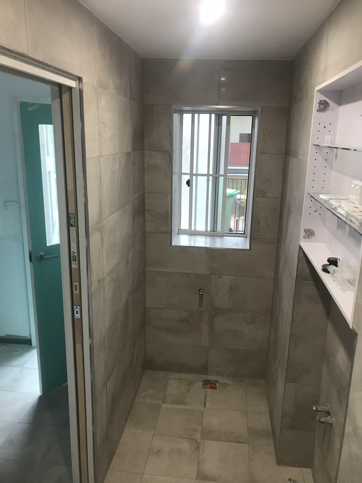 Wall and floor tiling in progress in a utility room