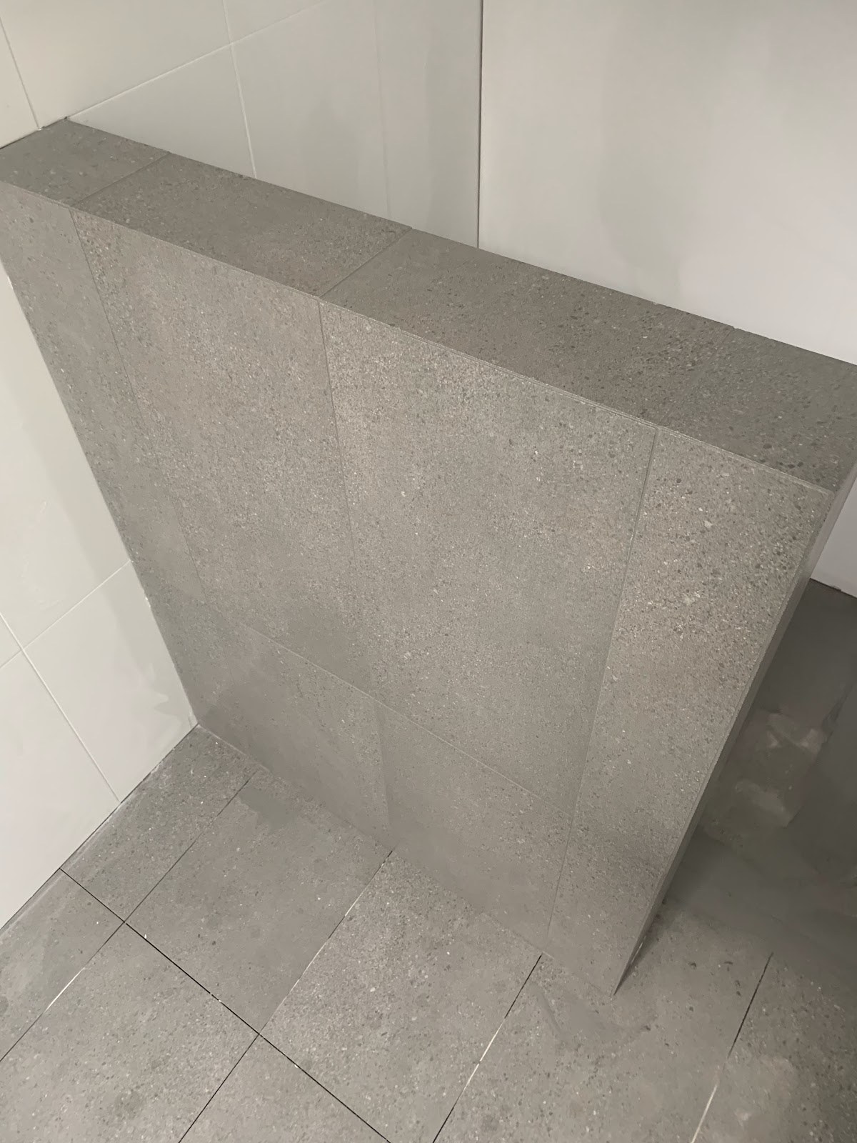 A grey stone-look tiled bathroom corner