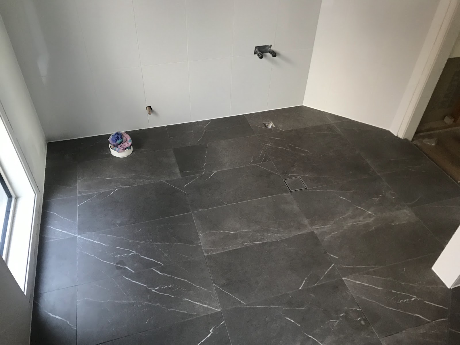 A dark marble-look floor beside a window